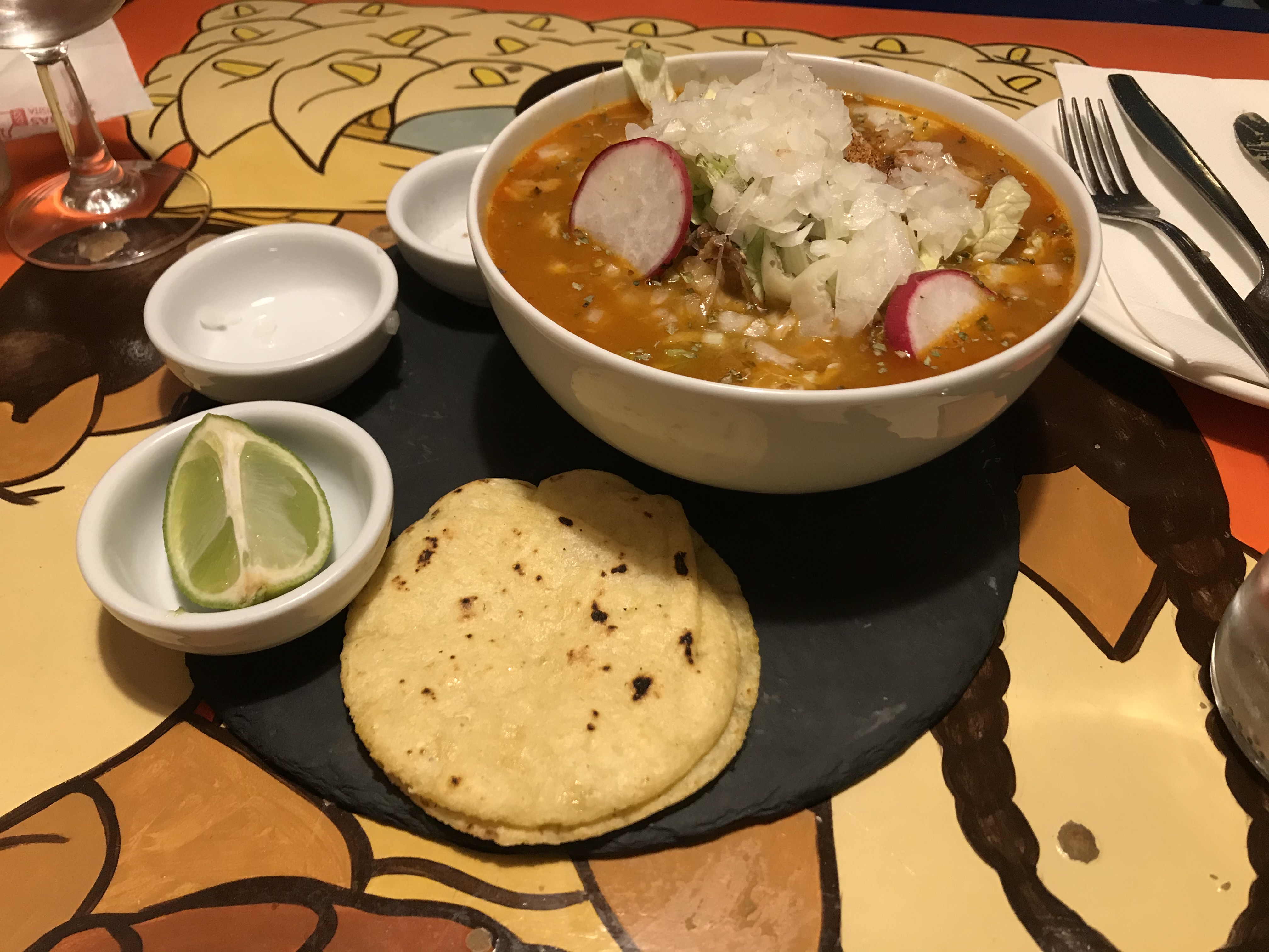 Pozole mit Tacos und Limettenstück im Restaurant El Chaparrito